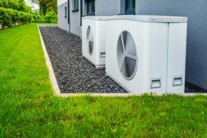 Zwei Luft-Wärmepumpen im Außenbereich eines neuen und modernen Stadthauses, grünes Konzept für erneuerbare Energien mit Wärmepumpe