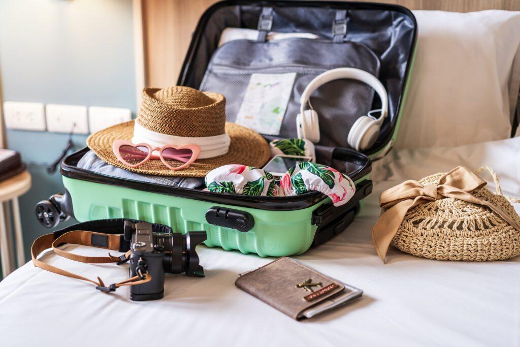 Offener Koffer mit Sommergepaeck auf Bett | Weidezelte